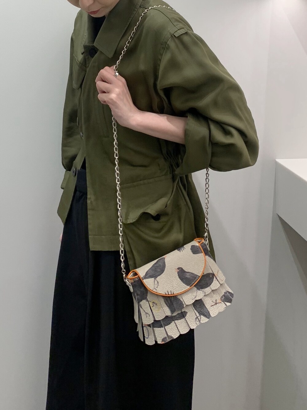 オレンジ系のショルダーバッグ、シルバー系のキーケース/キーアクセサリーを着用したレディースの春コーディネートの3枚目の写真