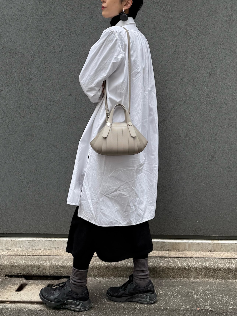 ベージュ系のショルダーバッグを着用したレディースの冬コーディネートの2枚目の写真