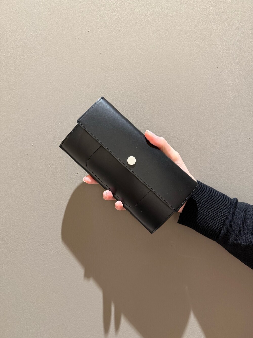 レッド系の財布、ブラック系の財布を着用したレディースの春コーディネートの3枚目の写真