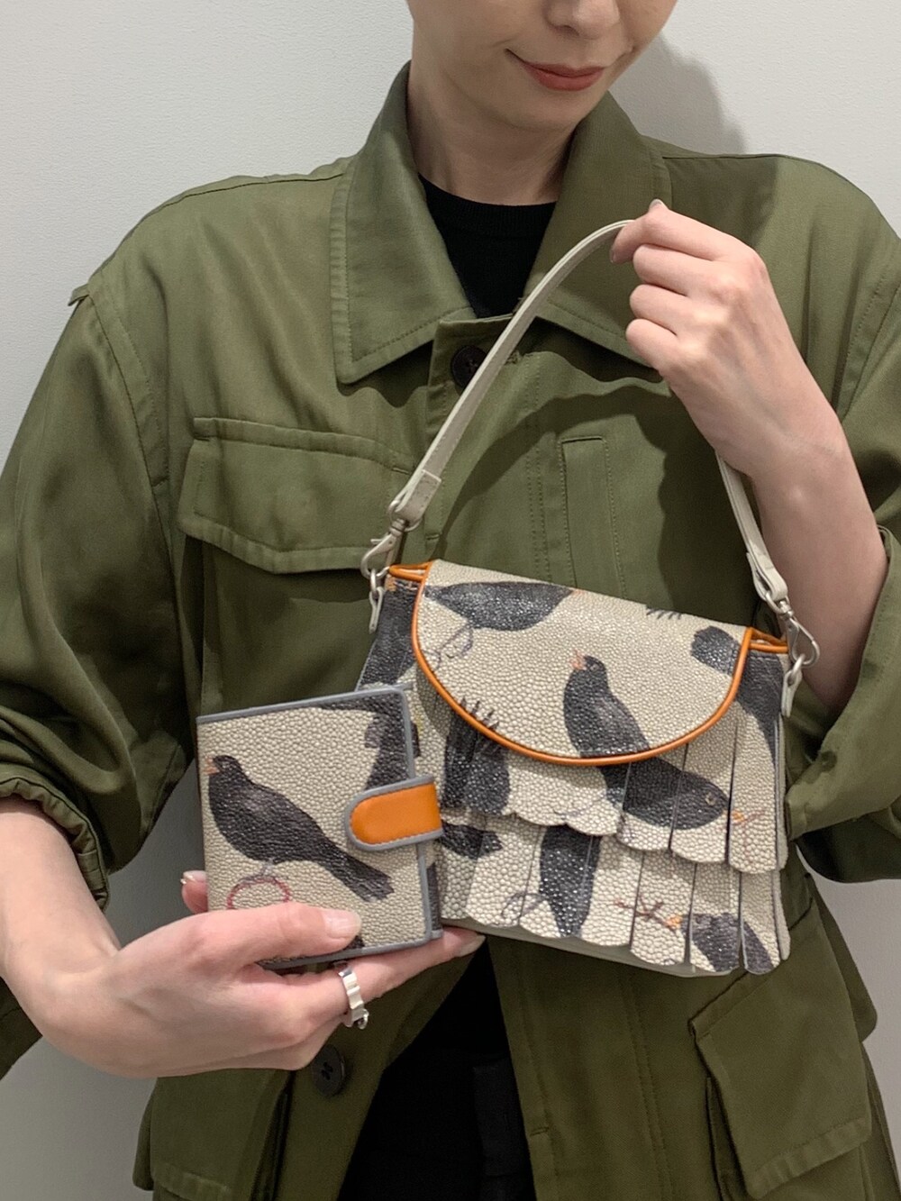 オレンジ系のショルダーバッグ、オレンジ系の財布を着用したレディースの春コーディネートの2枚目の写真