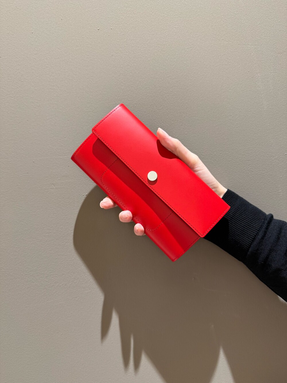 レッド系の財布、ブラック系の財布を着用したレディースの春コーディネートの6枚目の写真