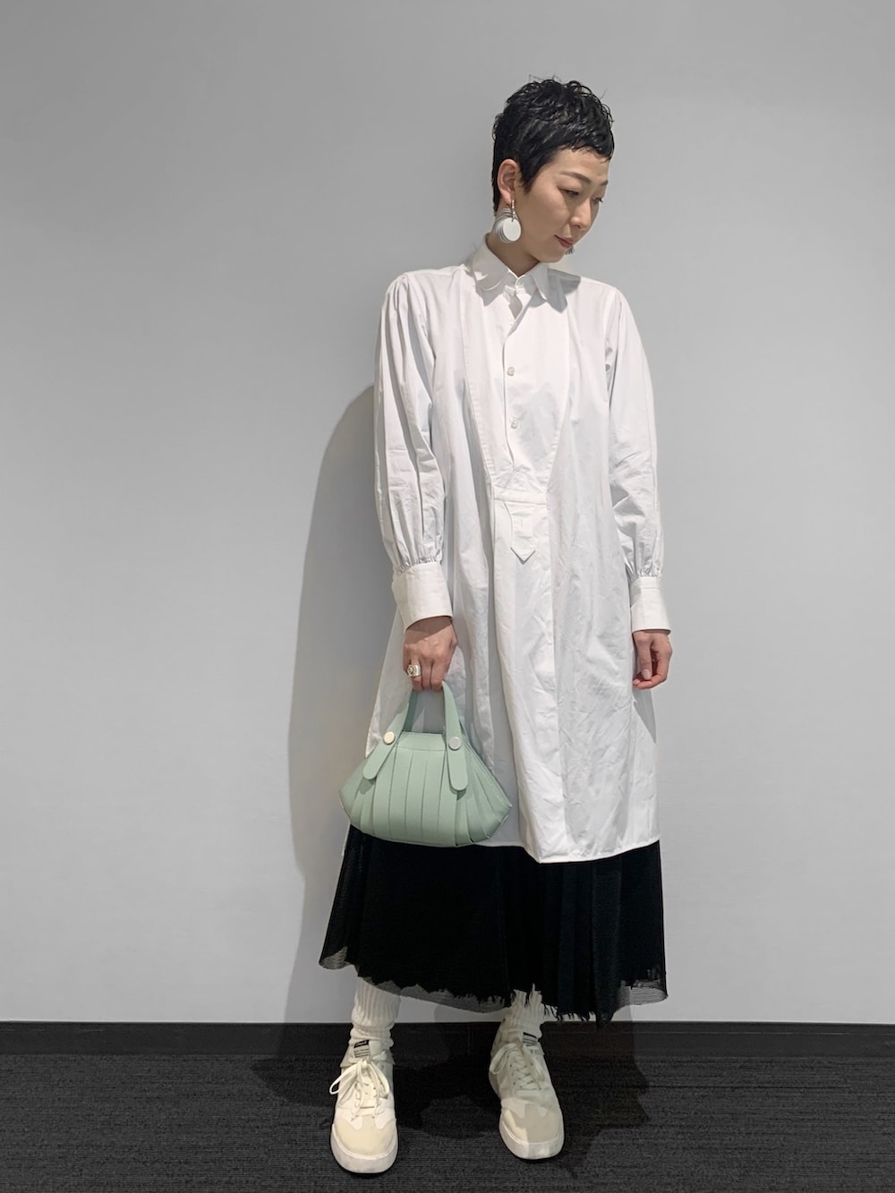 グリーン系のショルダーバッグを着用したレディースの春コーディネートの2枚目の写真