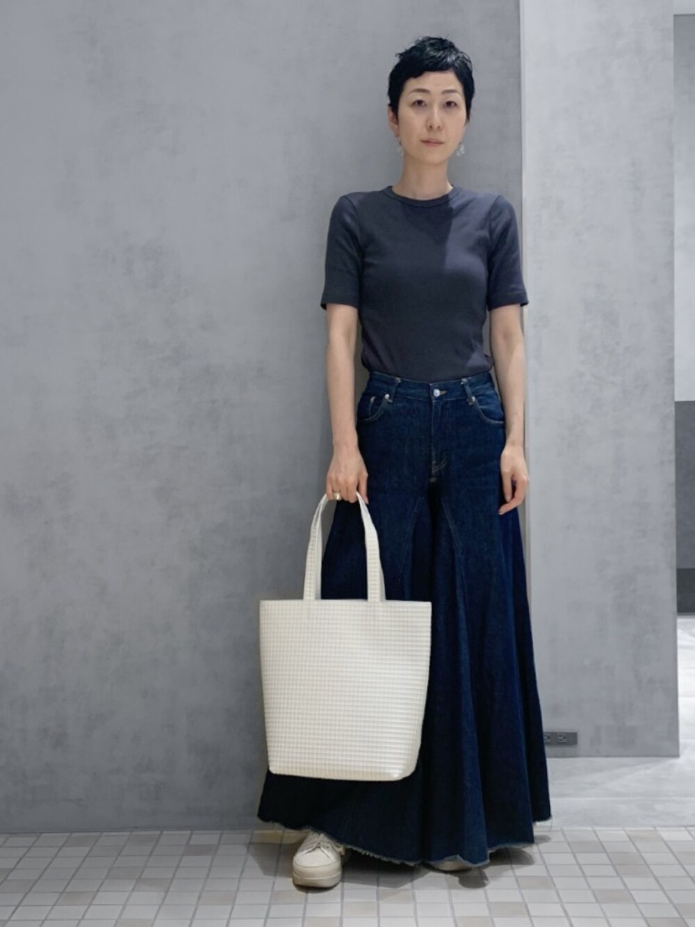 ホワイト系のトートバッグを着用したレディースの夏コーディネートの2枚目の写真