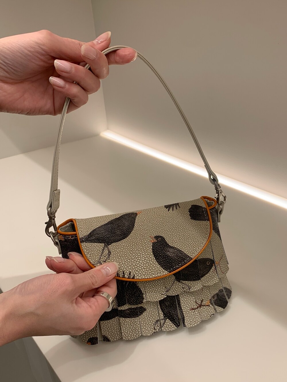 オレンジ系のショルダーバッグ、シルバー系のキーケース/キーアクセサリーを着用したレディースの春コーディネートの5枚目の写真