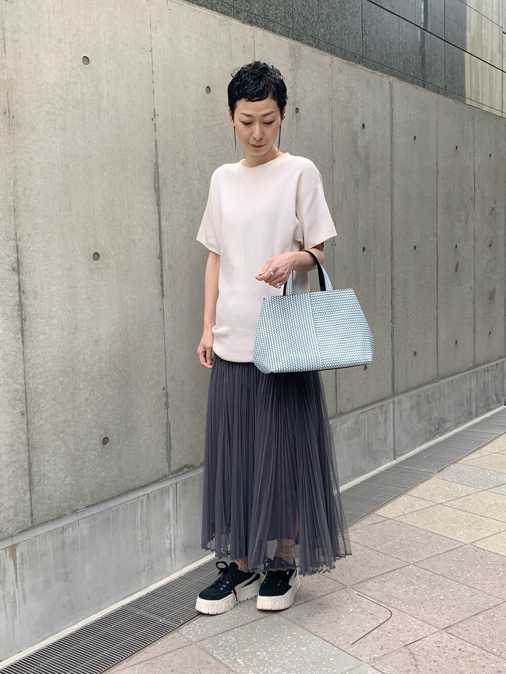 ブルー系のトートバッグを着用したレディースの夏コーディネートの2枚目の写真