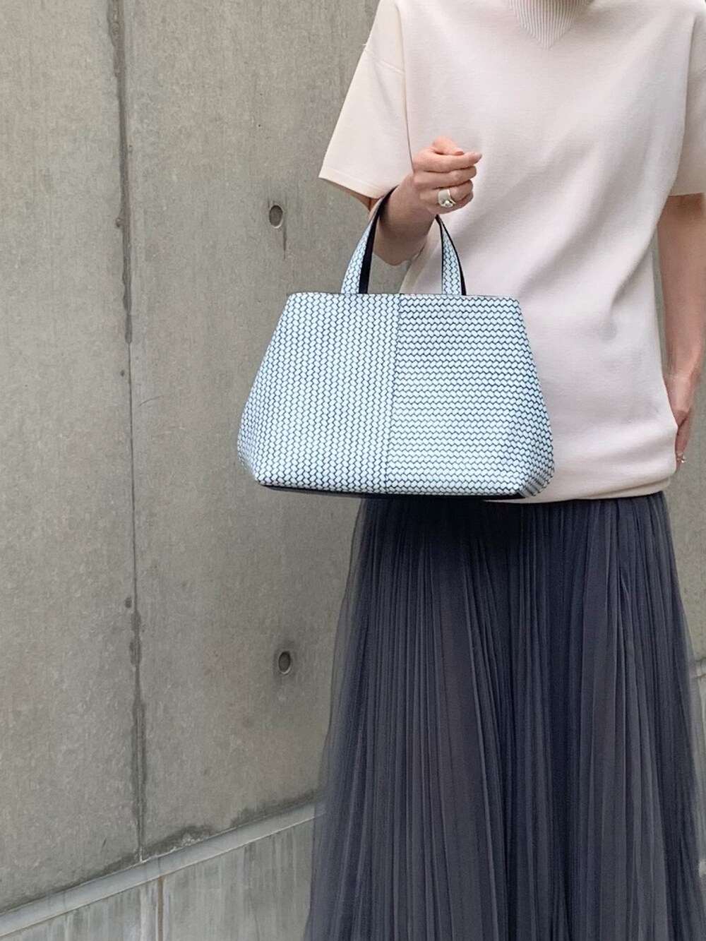 ブルー系のトートバッグを着用したレディースの夏コーディネートの3枚目の写真