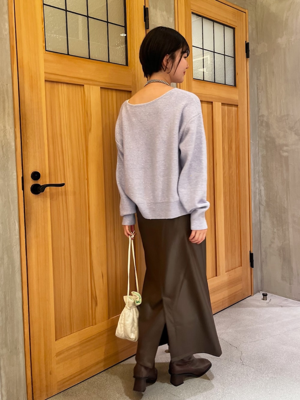 ホワイト系のその他アウター、パープル系のニット/セーター、ブラウン系のスカートを着用したレディースの冬コーディネートの5枚目の写真