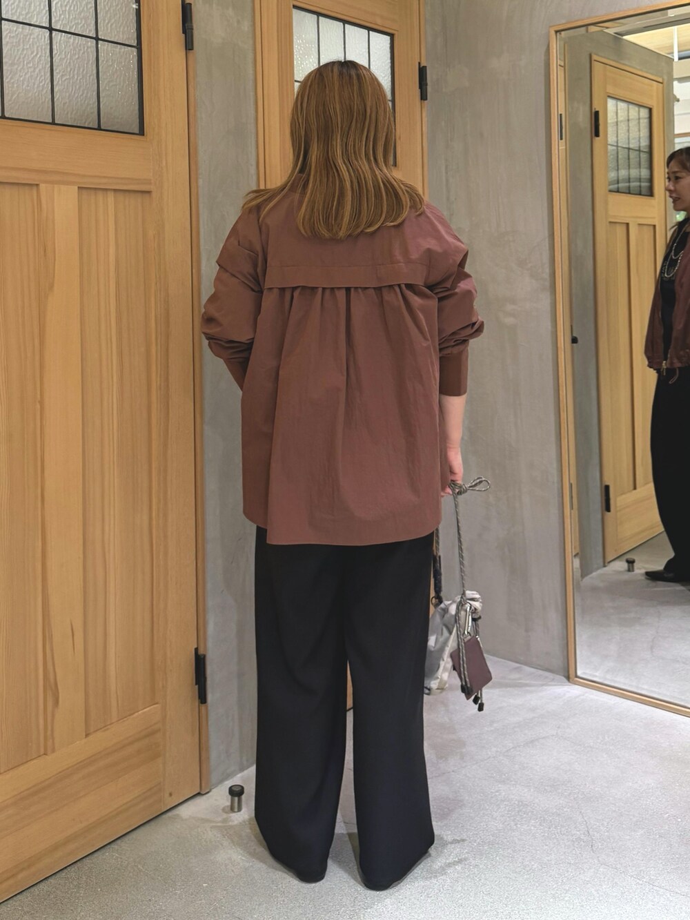 ブラウン系のブルゾンを着用したレディースの秋コーディネートの3枚目の写真