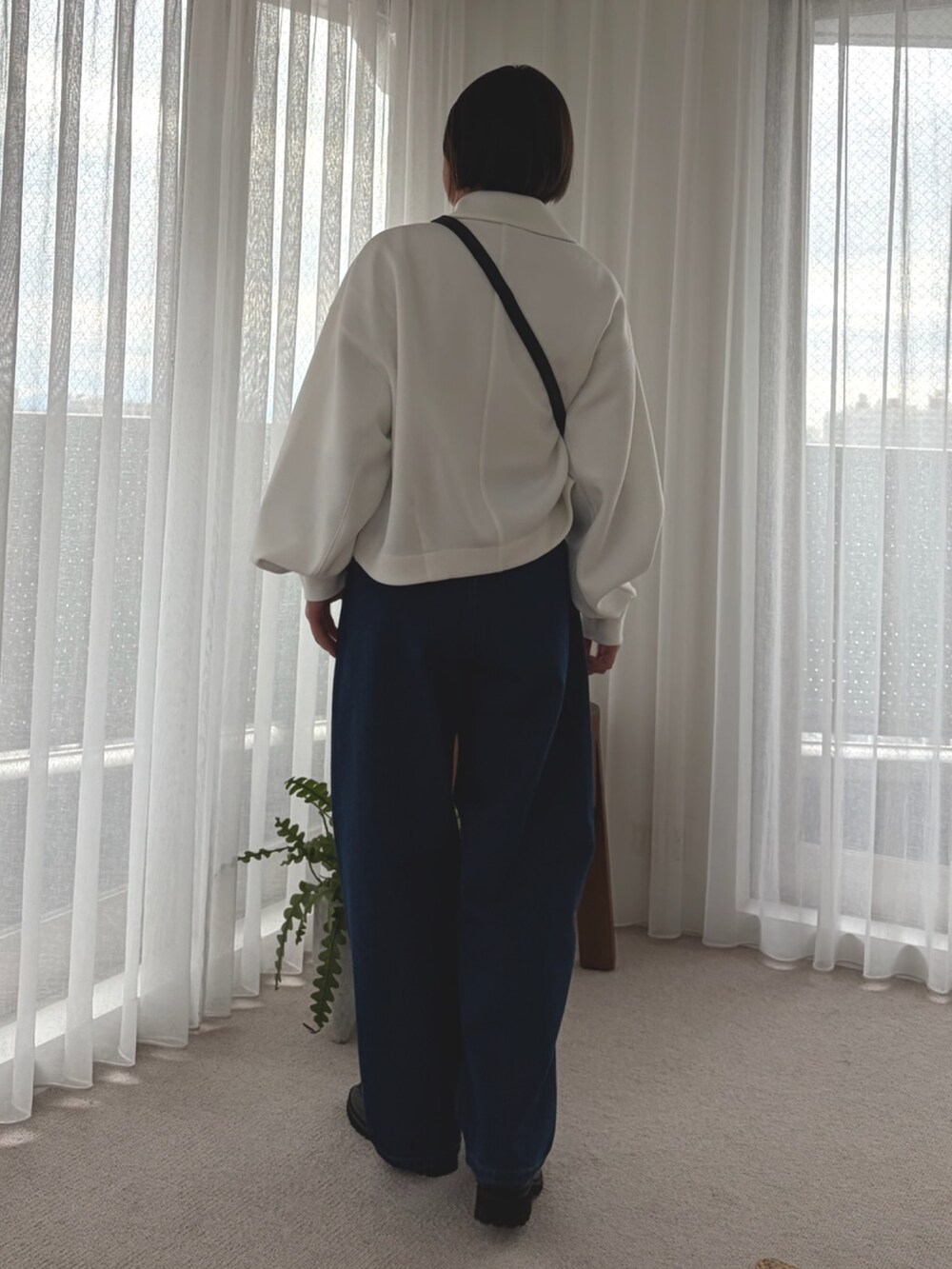 ホワイト系のブルゾン、ホワイト系のTシャツ/カットソー、ブルー系のデニムパンツを着用したレディースの冬コーディネートの3枚目の写真