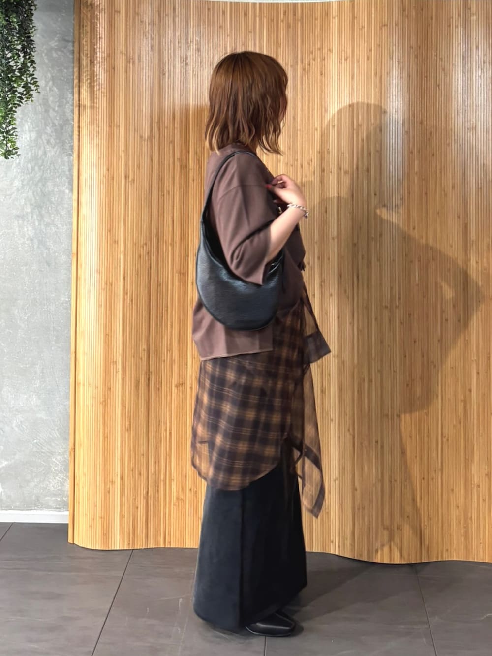 ブラウン系のTシャツ/カットソー、オレンジ系のTシャツ/カットソー、ブラック系のスカートを着用したレディースの夏コーディネートの2枚目の写真