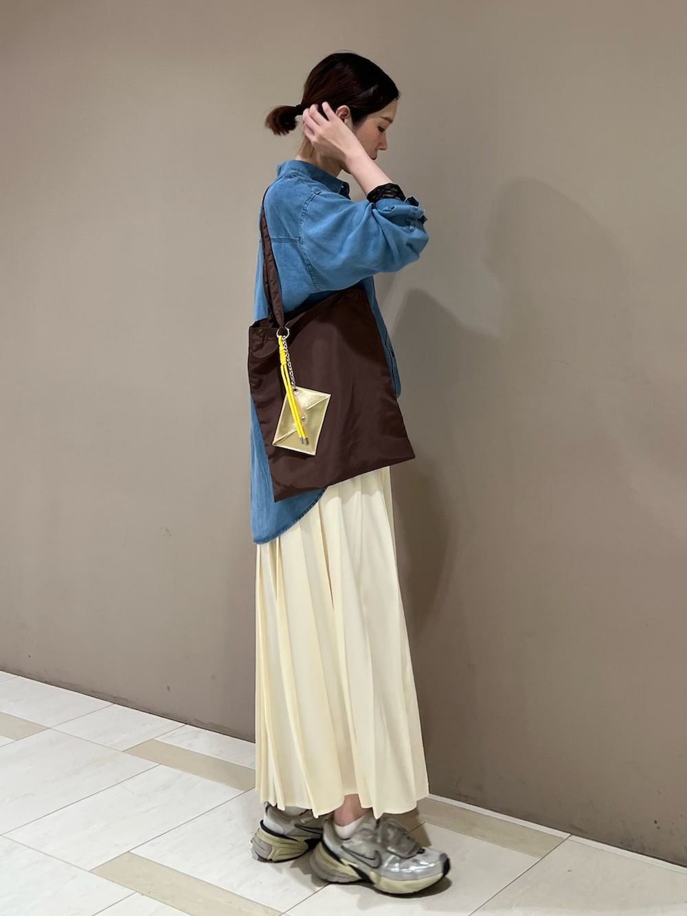 ブルー系のシャツ/ブラウス、ブラック系のTシャツ/カットソー、ホワイト系のスカートを着用したレディースの秋コーディネートの2枚目の写真