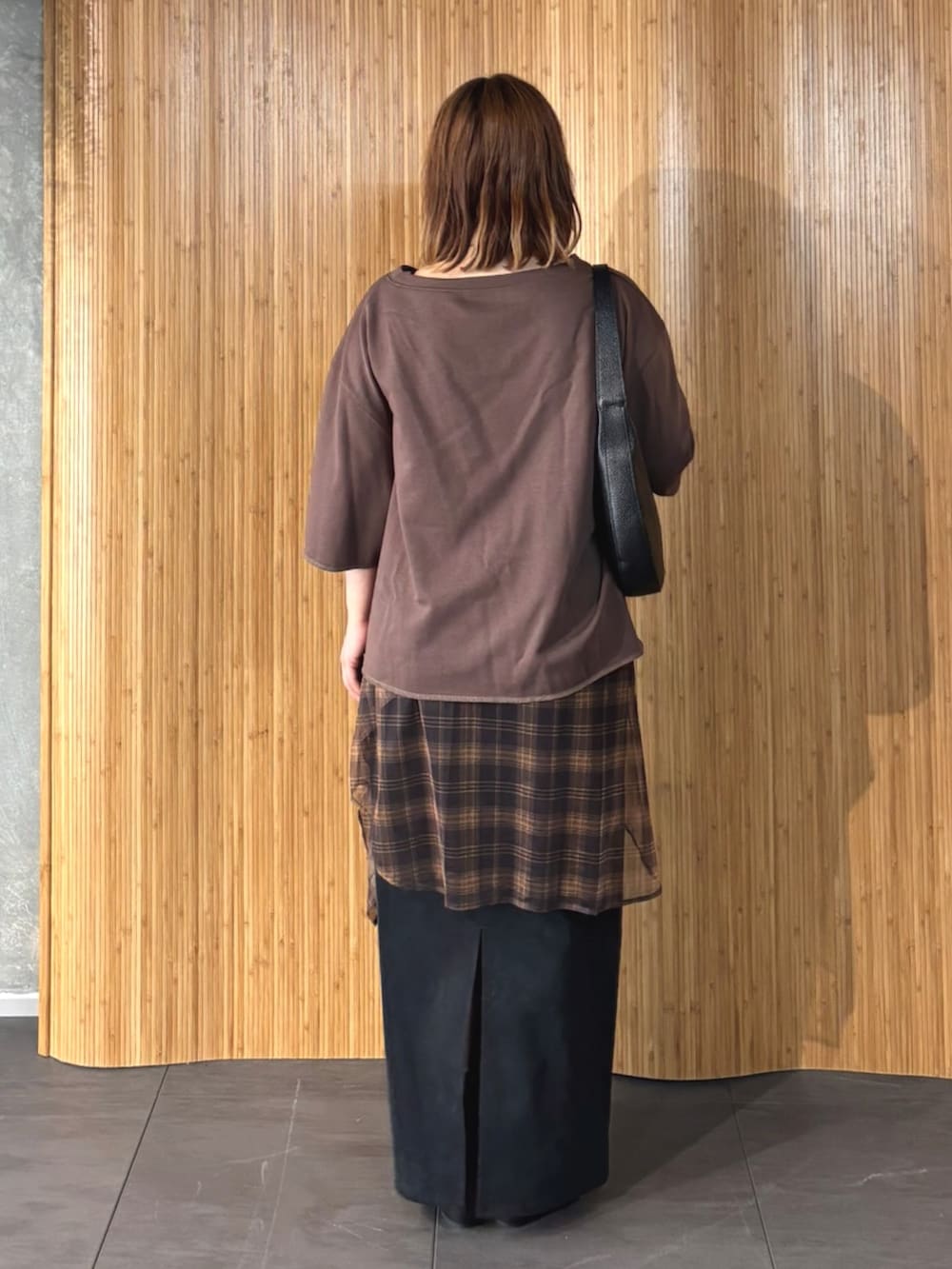 ブラウン系のTシャツ/カットソー、オレンジ系のTシャツ/カットソー、ブラック系のスカートを着用したレディースの夏コーディネートの3枚目の写真