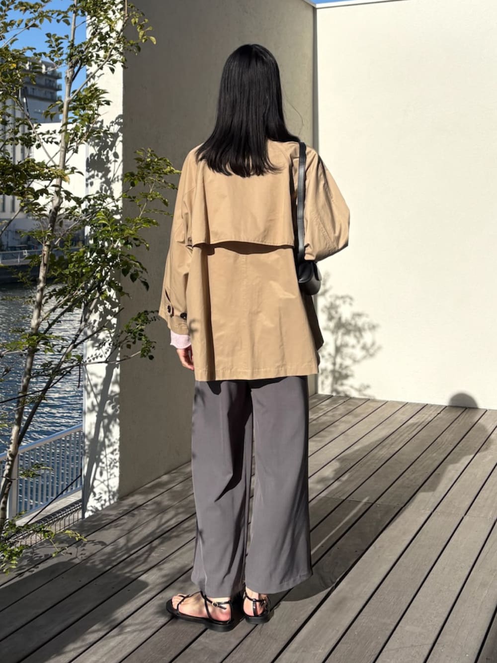 ベージュ系のトレンチコート、ピンク系のニット/セーター、グレー系のその他パンツを着用したレディースの春コーディネートの3枚目の写真