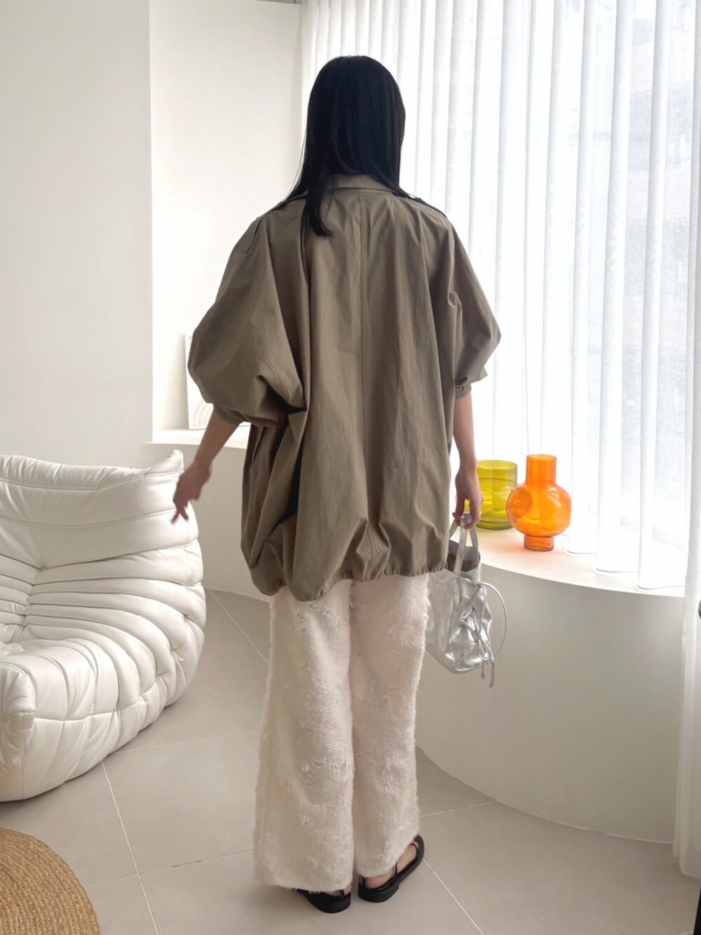 グリーン系のモッズコート、ホワイト系のその他パンツを着用したレディースの春コーディネートの3枚目の写真