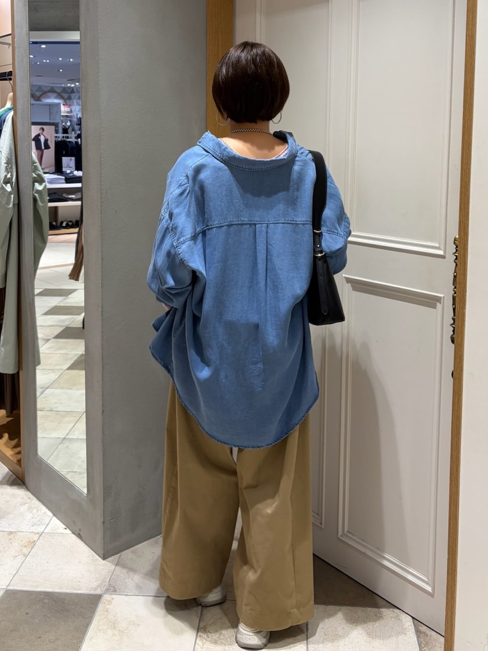 ピンク系のニット/セーター、ブルー系のシャツ/ブラウス、ベージュ系のその他パンツを着用したレディースの春コーディネートの3枚目の写真