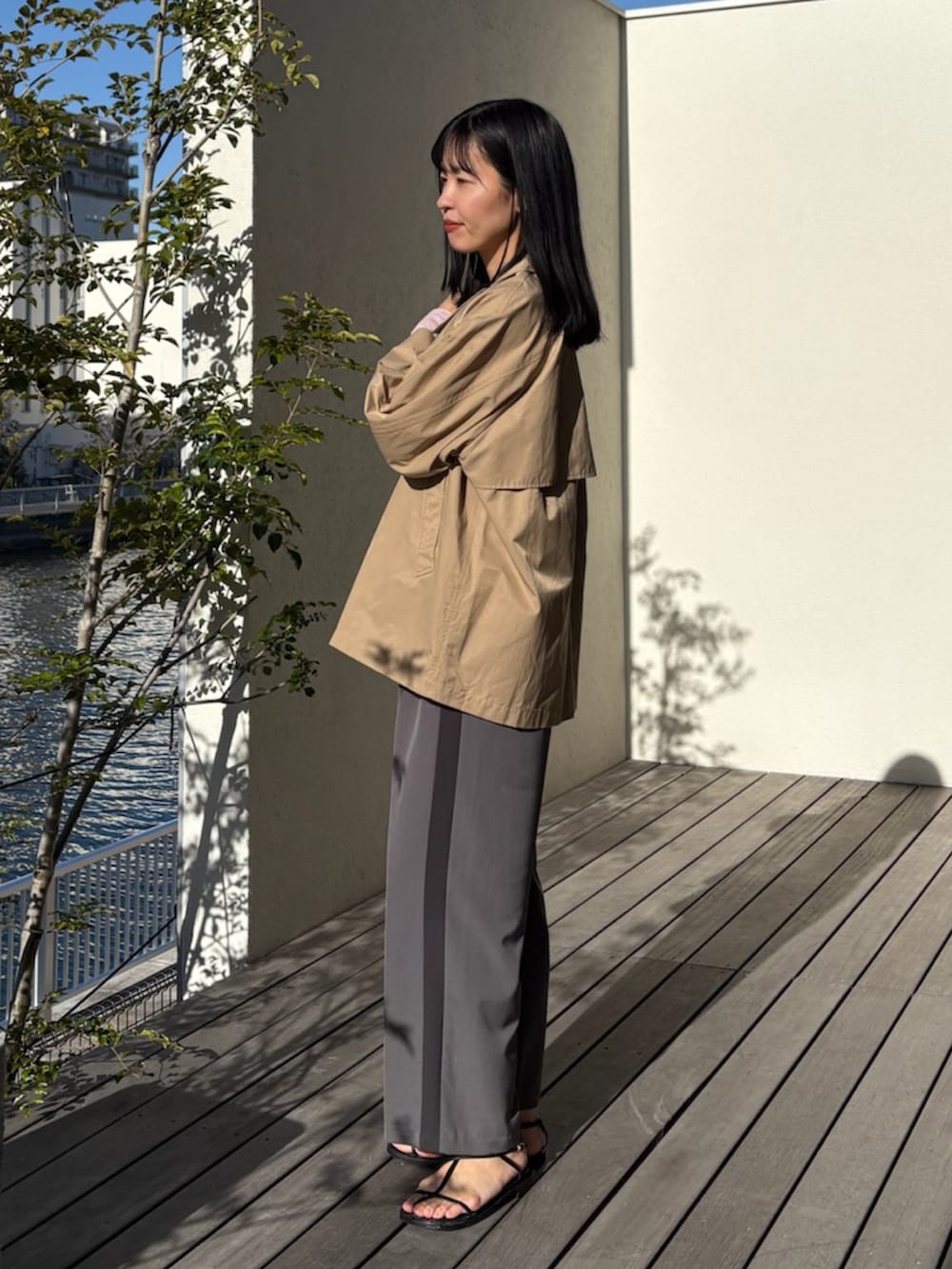 ベージュ系のトレンチコート、ピンク系のニット/セーター、グレー系のその他パンツを着用したレディースの春コーディネートの2枚目の写真