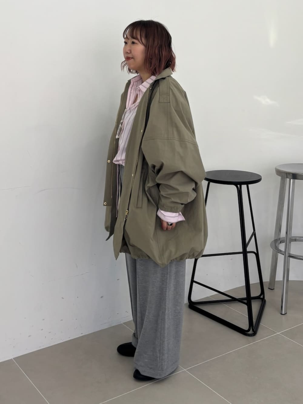 グリーン系のモッズコート、グレー系のその他パンツを着用したレディースの春コーディネートの2枚目の写真