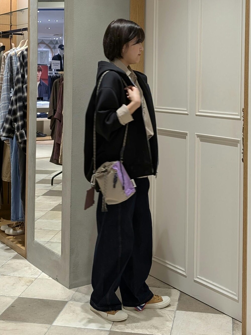 ブルー系のデニムパンツ、ブラック系のパーカーを着用したレディースの秋コーディネートの2枚目の写真
