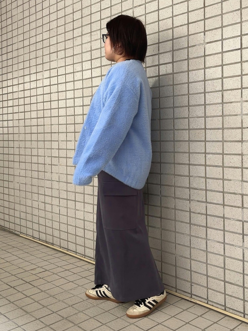 ホワイト系のTシャツ/カットソー、ブルー系のカーディガン/ボレロ、グレー系のスカートを着用したレディースの秋コーディネートの2枚目の写真