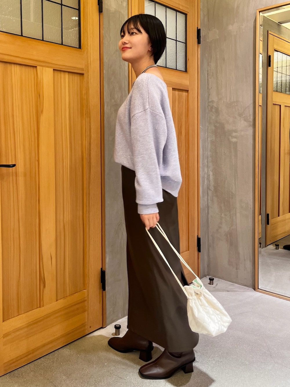 ホワイト系のその他アウター、パープル系のニット/セーター、ブラウン系のスカートを着用したレディースの冬コーディネートの4枚目の写真