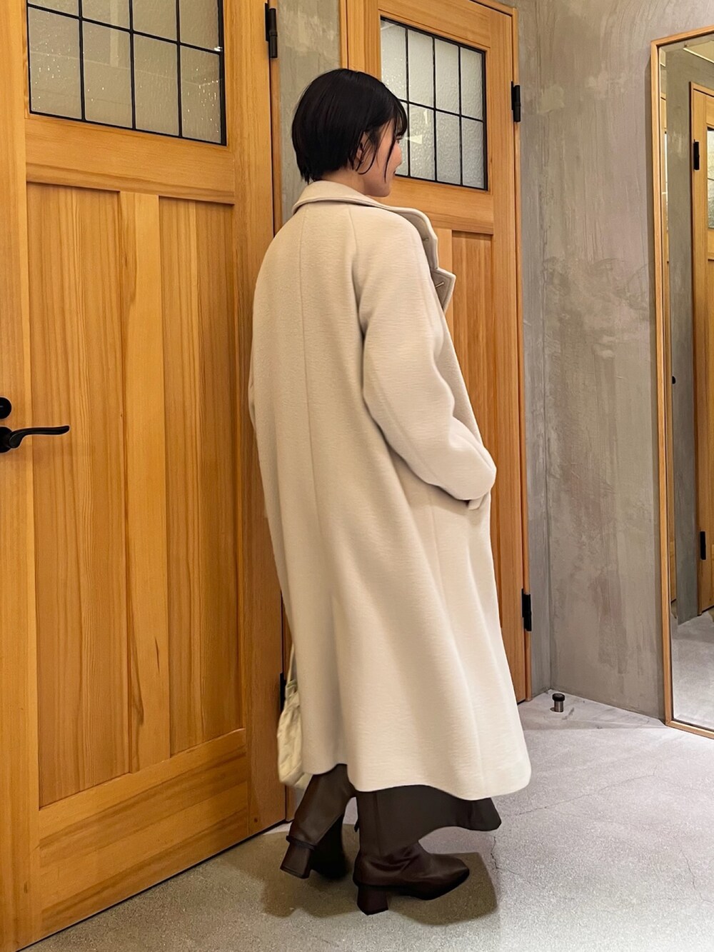 ホワイト系のその他アウター、パープル系のニット/セーター、ブラウン系のスカートを着用したレディースの冬コーディネートの2枚目の写真