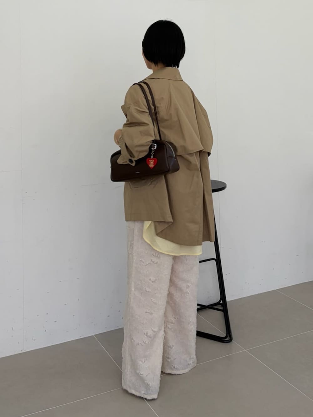 ベージュ系のトレンチコート、ホワイト系のその他パンツを着用したレディースの春コーディネートの2枚目の写真