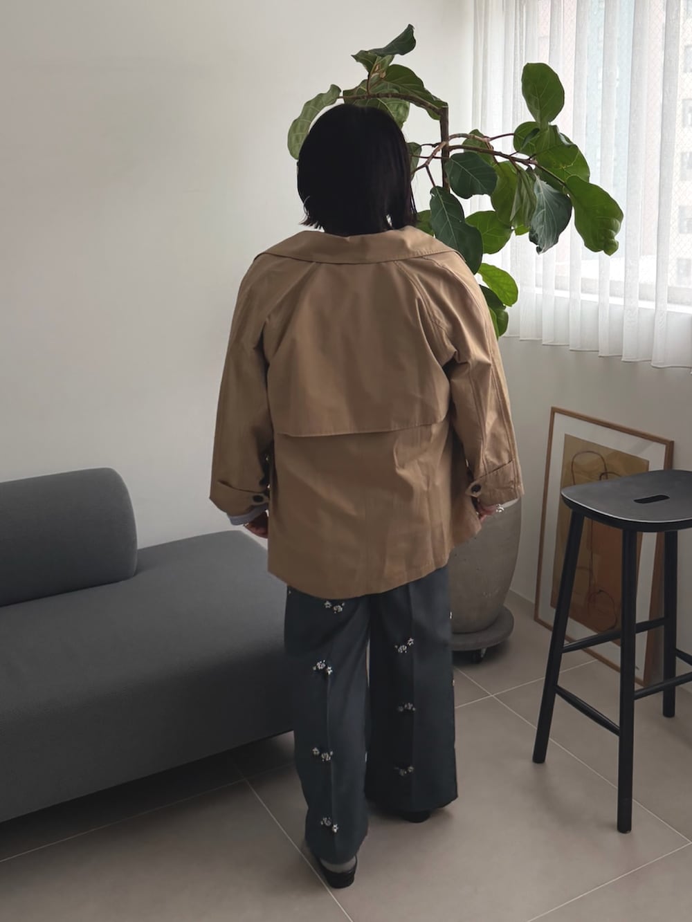 ベージュ系のトレンチコート、ブルー系のニット/セーター、グレー系のその他パンツを着用したレディースの春コーディネートの3枚目の写真