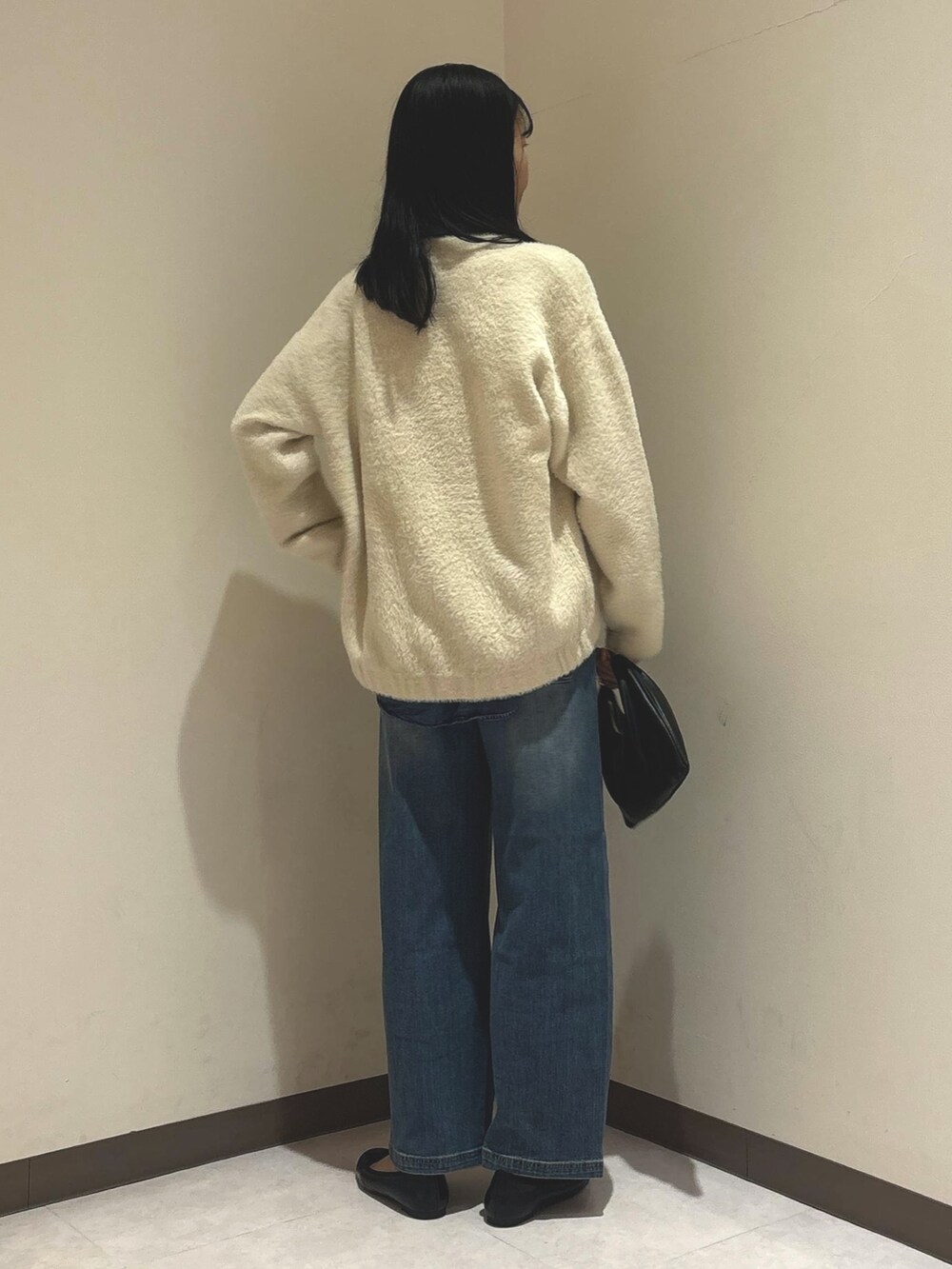 ブルー系のシャツ/ブラウス、ホワイト系のカーディガン/ボレロ、ブルー系のデニムパンツを着用したレディースの秋コーディネートの3枚目の写真