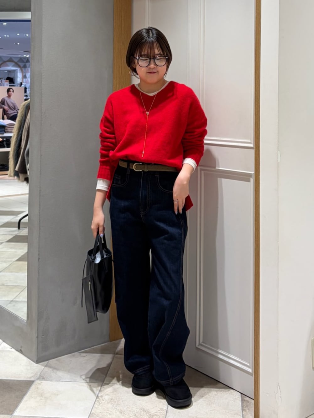 レッド系のニット/セーター、グレー系のその他アウター、ブルー系のデニムパンツを着用したレディースの冬コーディネートの4枚目の写真