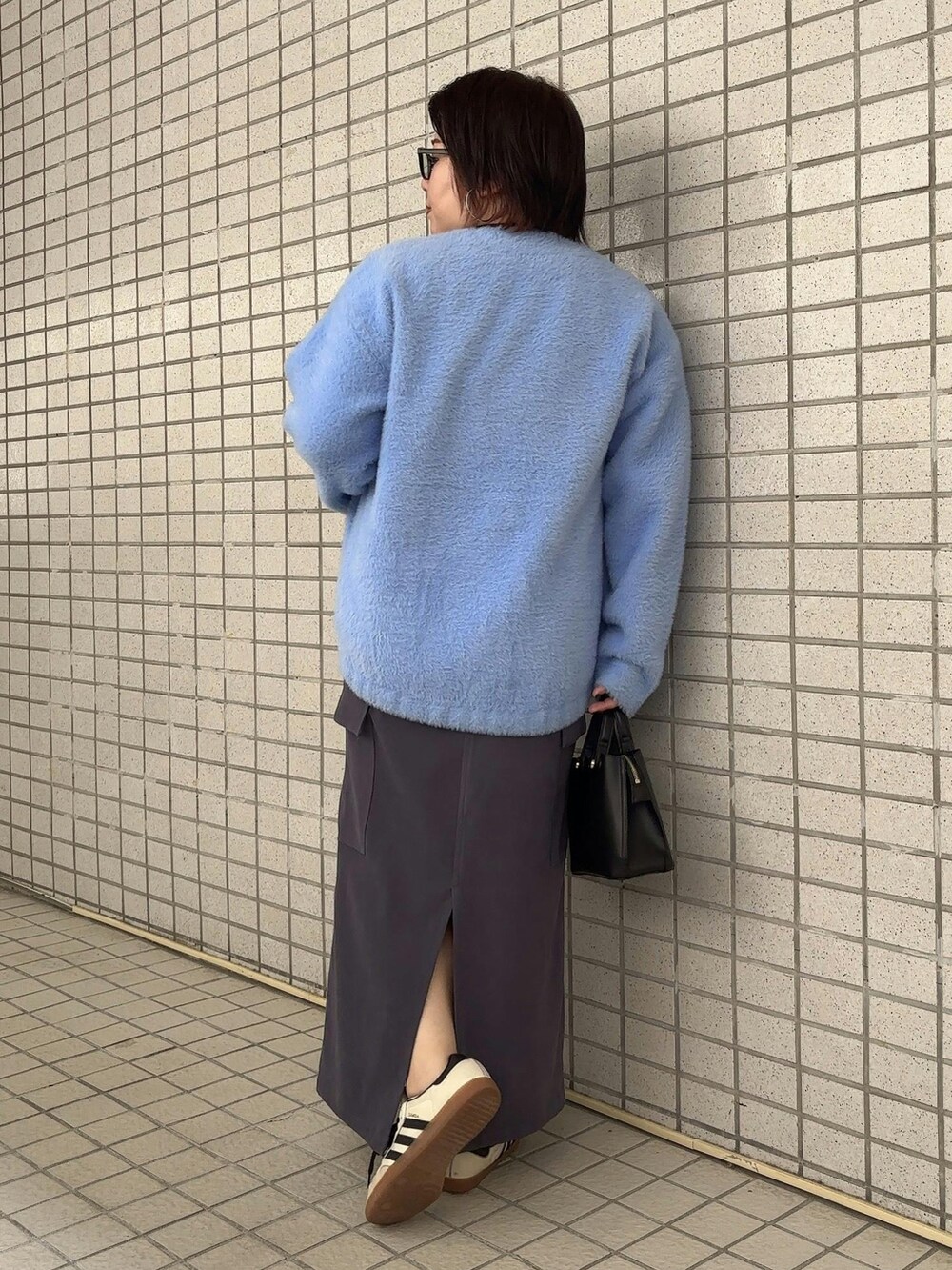 ホワイト系のTシャツ/カットソー、ブルー系のカーディガン/ボレロ、グレー系のスカートを着用したレディースの秋コーディネートの3枚目の写真