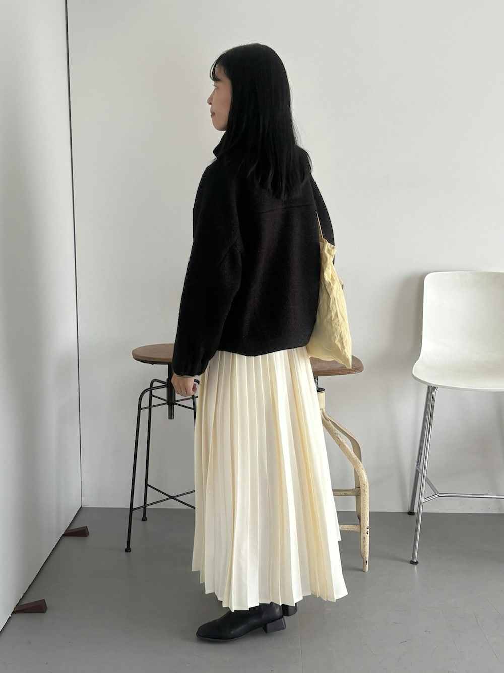 ブラック系のブルゾン、ホワイト系のスカートを着用したレディースの秋コーディネートの2枚目の写真