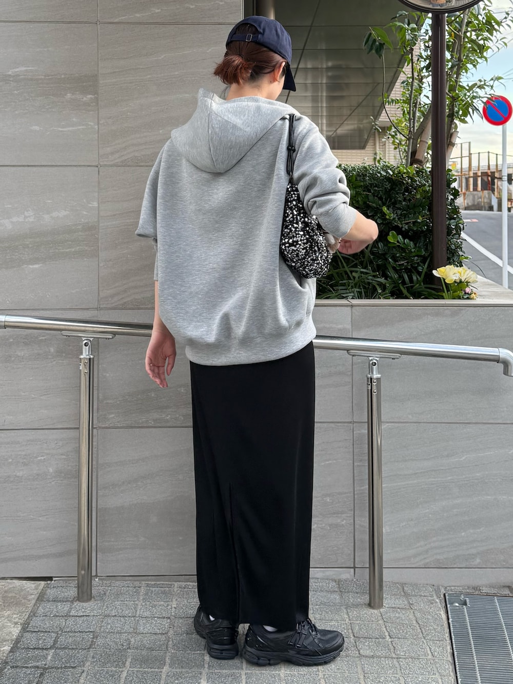 グレー系のパーカー、ブラック系のスカートを着用したレディースの秋コーディネートの3枚目の写真