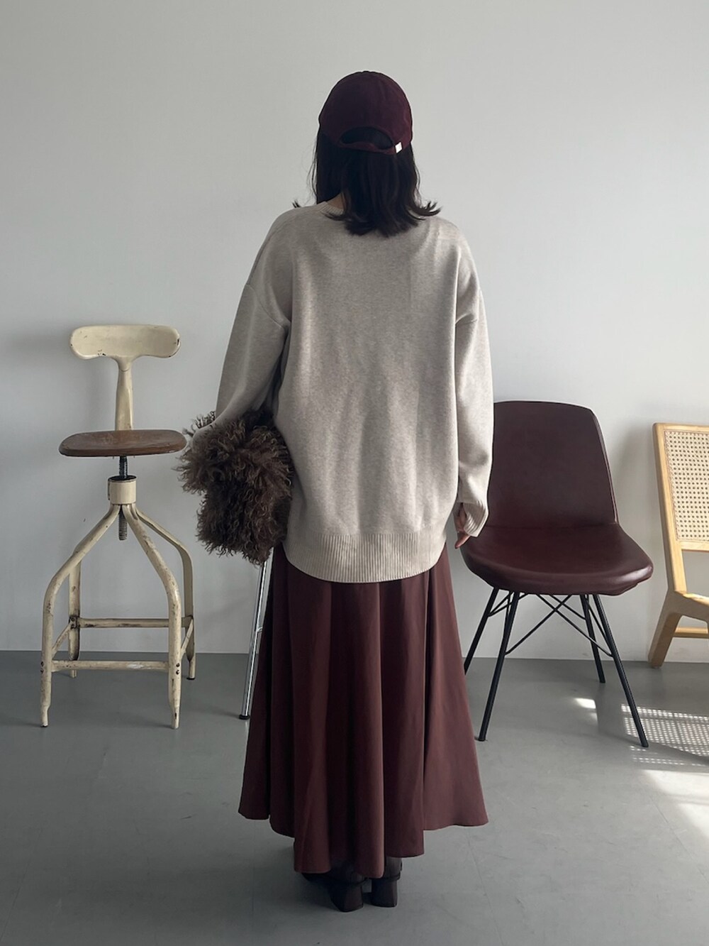 ベージュ系のピーコート、ベージュ系のニット/セーター、ブラウン系のスカートを着用したレディースの冬コーディネートの3枚目の写真