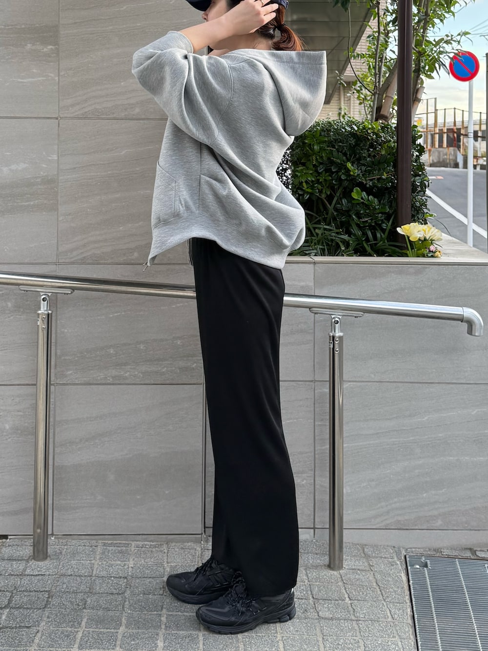 グレー系のパーカー、ブラック系のスカートを着用したレディースの秋コーディネートの2枚目の写真