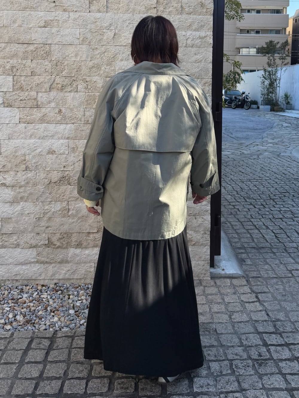 イエロー系のニット/セーター、グリーン系のトレンチコートを着用したレディースの春コーディネートの3枚目の写真