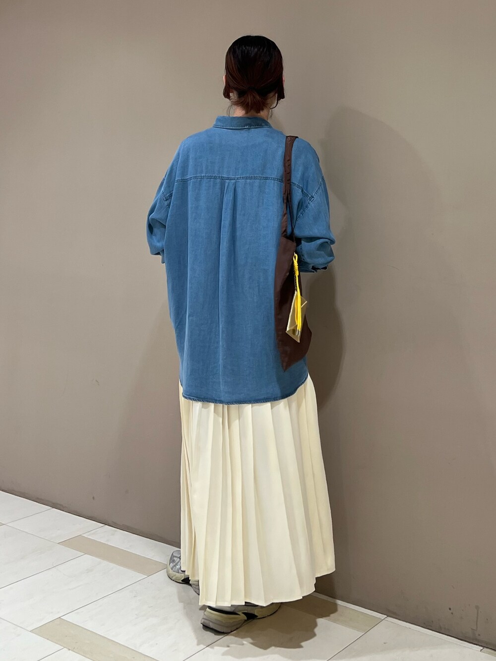 ブルー系のシャツ/ブラウス、ブラック系のTシャツ/カットソー、ホワイト系のスカートを着用したレディースの秋コーディネートの3枚目の写真