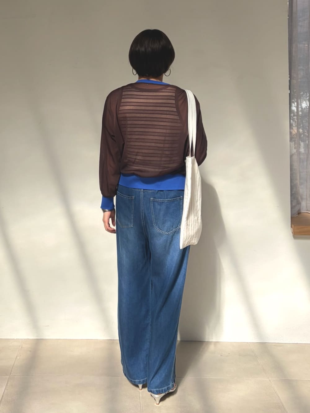 ブラウン系のカーディガン/ボレロ、ブラウン系のタンクトップを着用したレディースの春コーディネートの3枚目の写真