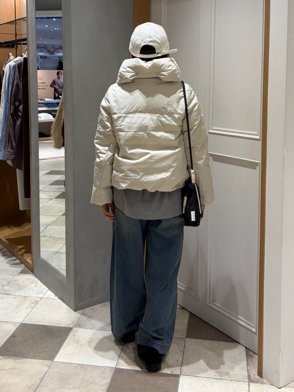 ホワイト系のダウンジャケット/コート、ブルー系のデニムパンツを着用したレディースの秋コーディネートの3枚目の写真