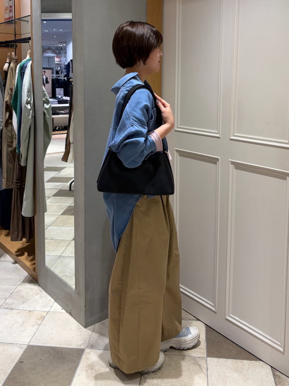 ピンク系のニット/セーター、ブルー系のシャツ/ブラウス、ベージュ系のその他パンツを着用したレディースの春コーディネートの2枚目の写真