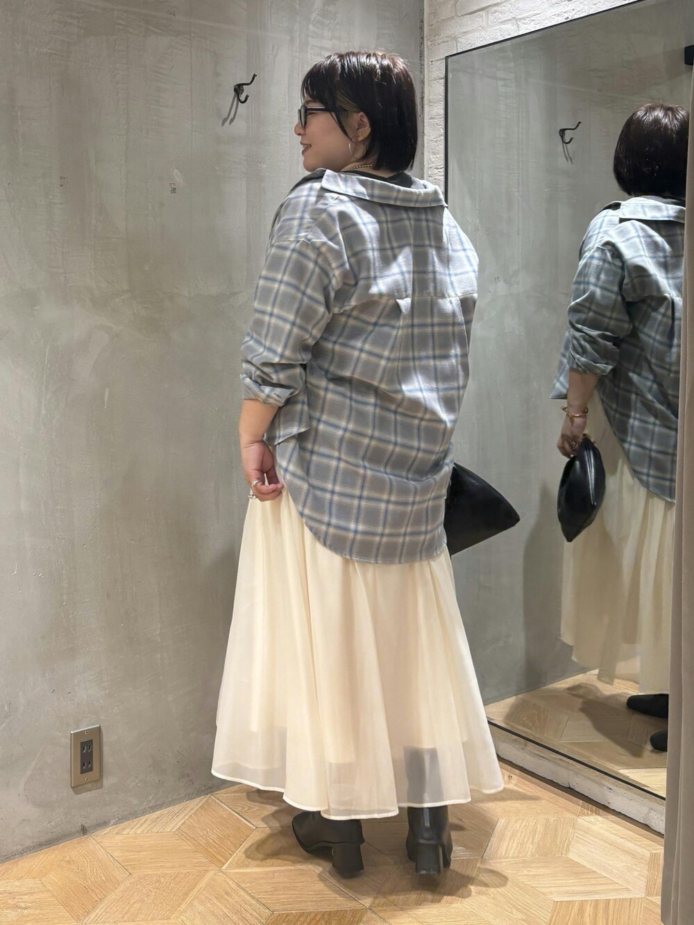 ホワイト系のスカート、ブラウン系のブーツ、ブルー系のシャツ/ブラウスを着用したレディースの秋コーディネートの3枚目の写真