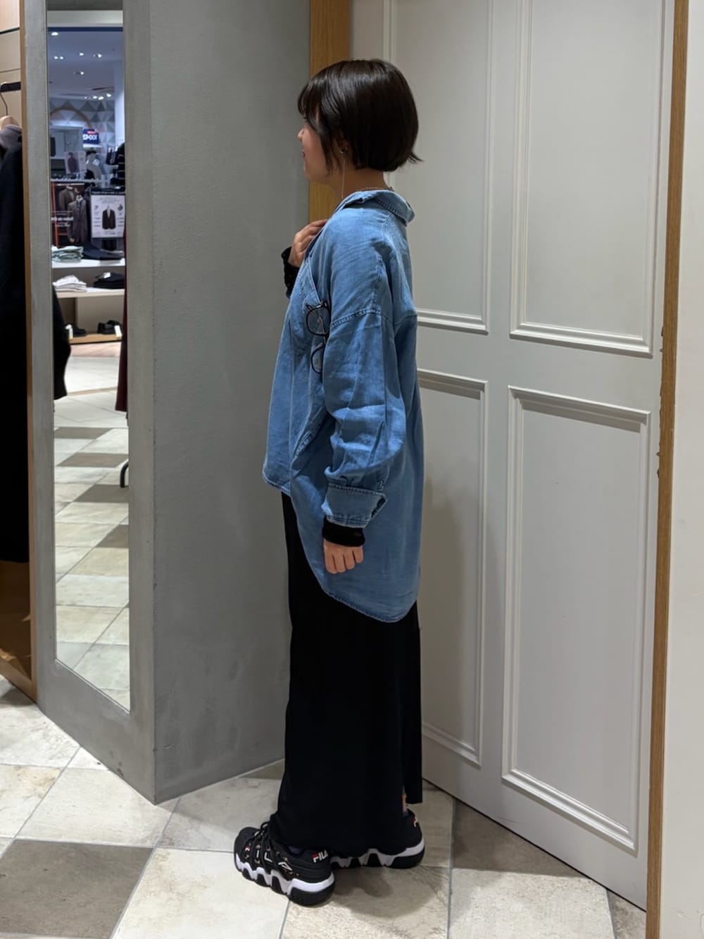 ブルー系のシャツ/ブラウス、ブラック系のスカート、ブラック系のTシャツ/カットソーを着用したレディースの春コーディネートの2枚目の写真