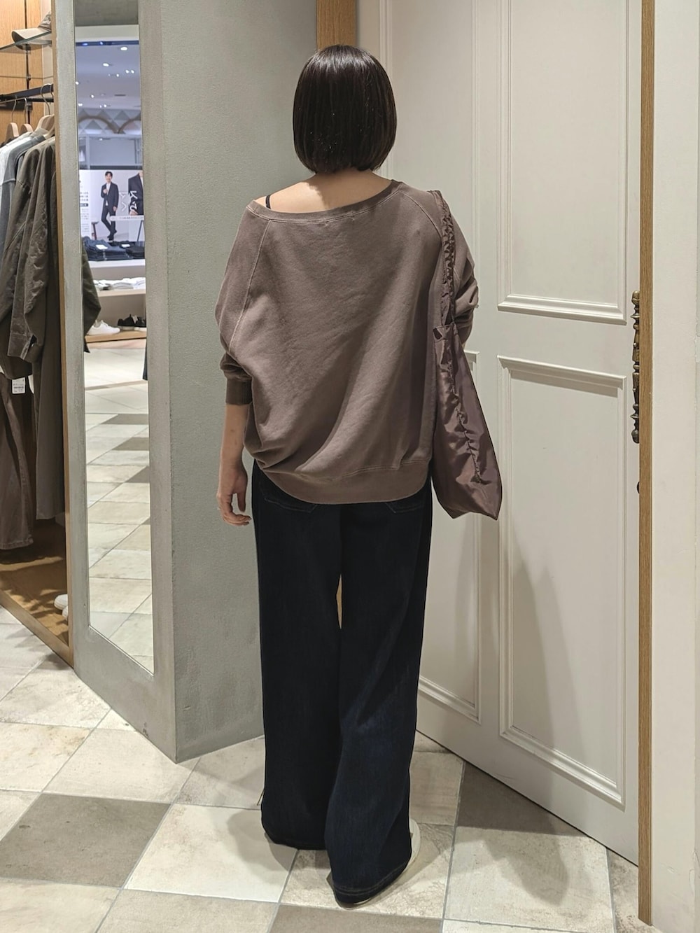 ブラウン系のスウェット、ブルー系のデニムパンツを着用したレディースの秋コーディネートの3枚目の写真