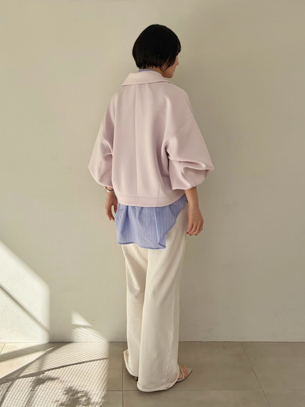 ピンク系のブルゾン、ブルー系のシャツ/ブラウス、ホワイト系のスウェットパンツを着用したレディースの冬コーディネートの3枚目の写真
