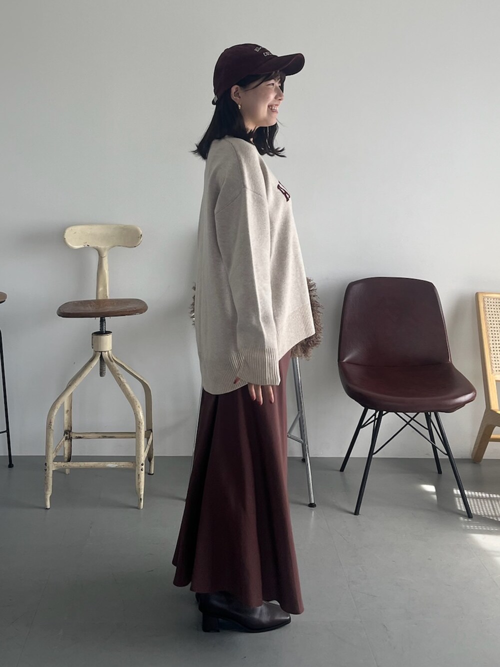 ベージュ系のピーコート、ベージュ系のニット/セーター、ブラウン系のスカートを着用したレディースの冬コーディネートの2枚目の写真