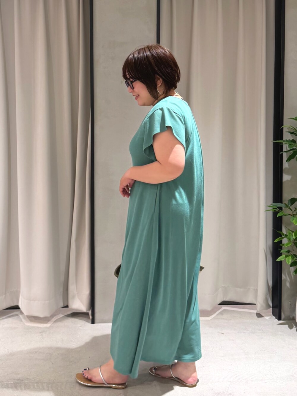 グリーン系のワンピースを着用したレディースの夏コーディネートの2枚目の写真