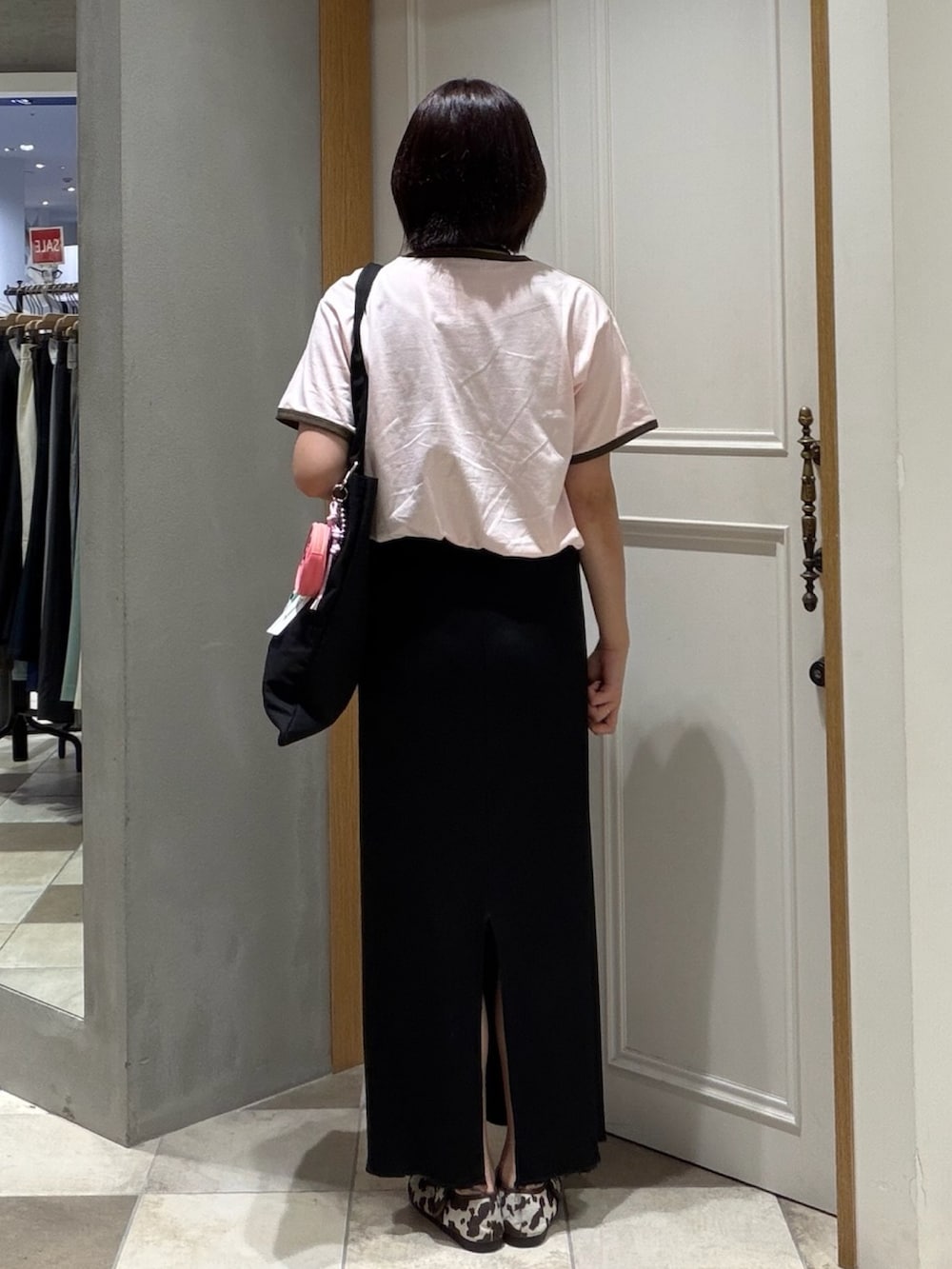 ピンク系のTシャツ/カットソー、ブラック系のスカート、ブラック系のトートバッグを着用したレディースの夏コーディネートの3枚目の写真