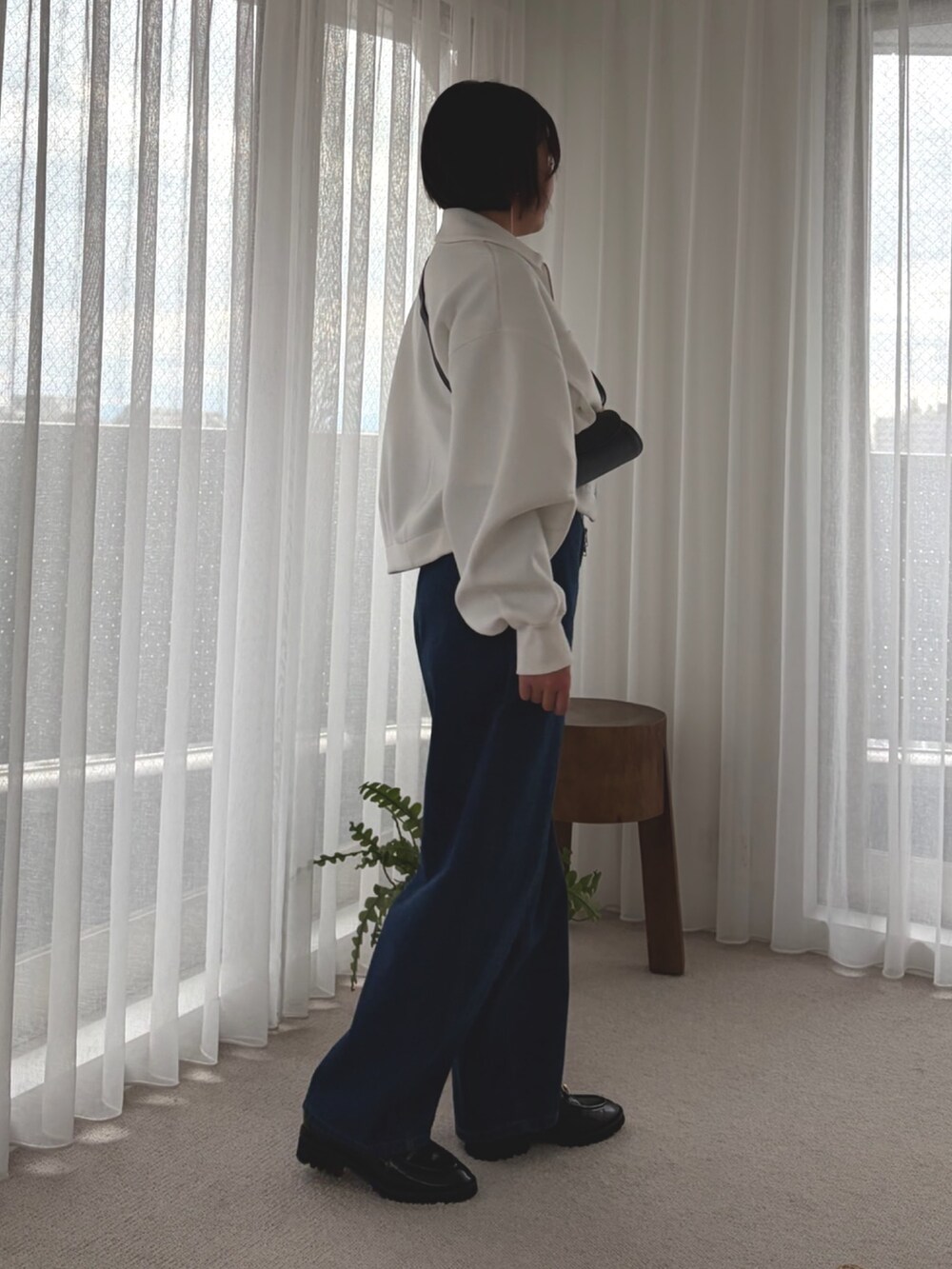 ホワイト系のブルゾン、ホワイト系のTシャツ/カットソー、ブルー系のデニムパンツを着用したレディースの冬コーディネートの2枚目の写真