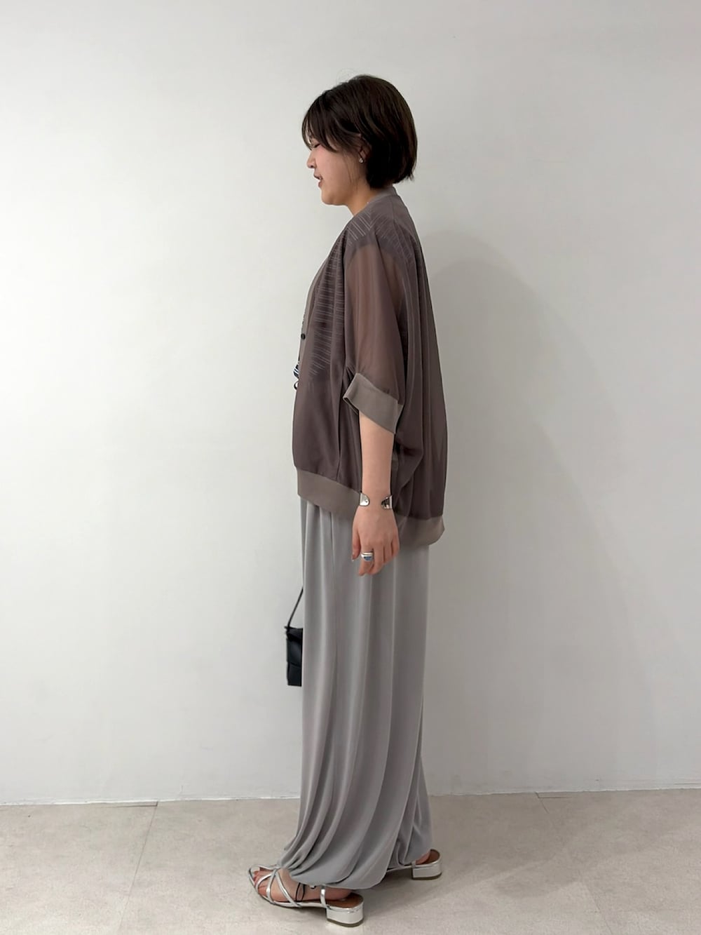 ブラウン系のカーディガン/ボレロ、グレー系のデニムパンツ、シルバー系のサンダルを着用したレディースの夏コーディネートの2枚目の写真