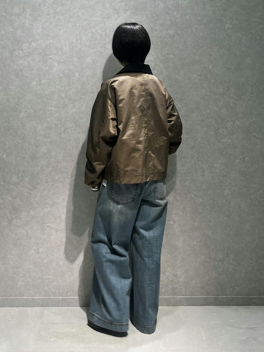 グリーン系のTシャツ/カットソー、グリーン系のその他アウター、ブルー系のデニムパンツを着用したレディースの秋コーディネートの3枚目の写真
