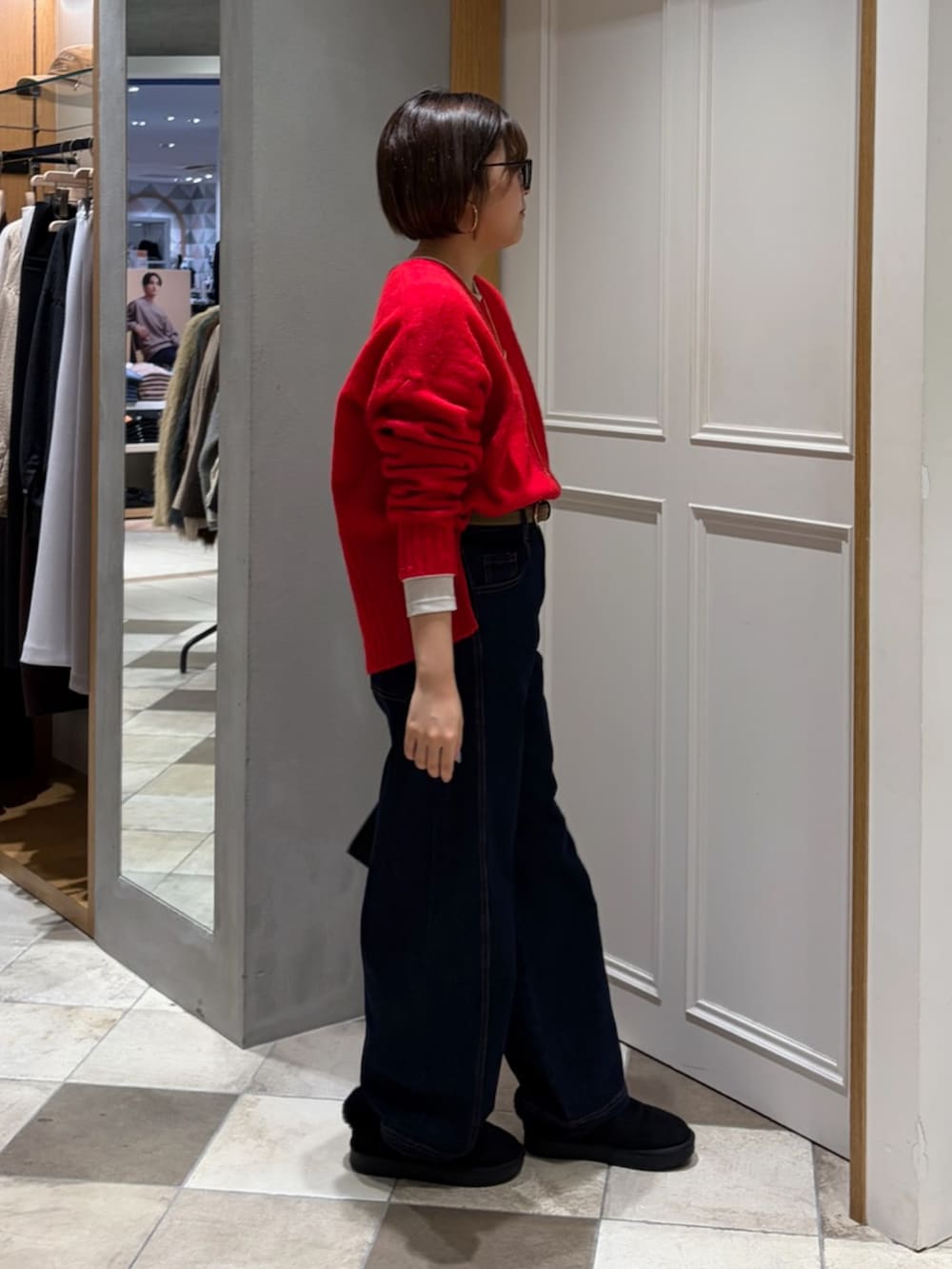 レッド系のニット/セーター、グレー系のその他アウター、ブルー系のデニムパンツを着用したレディースの冬コーディネートの5枚目の写真